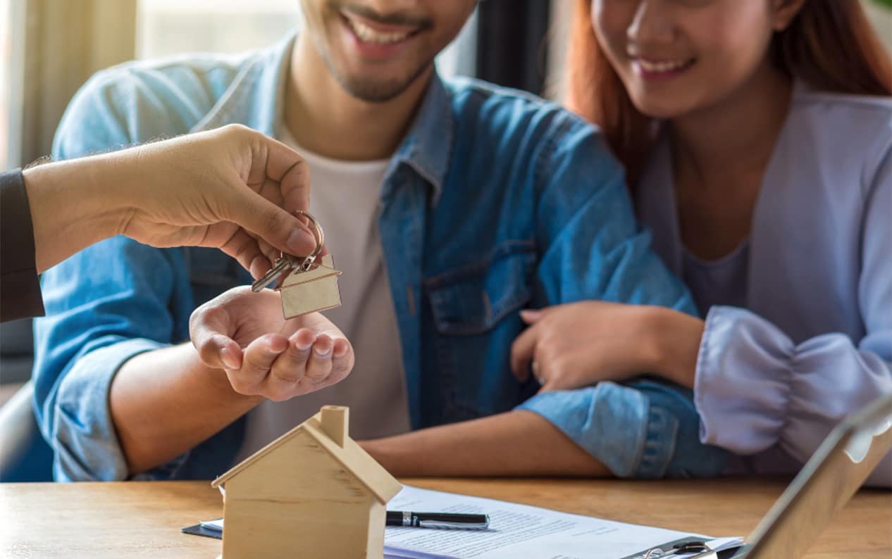 A couple receiving keys to a new home from a real estate agent.