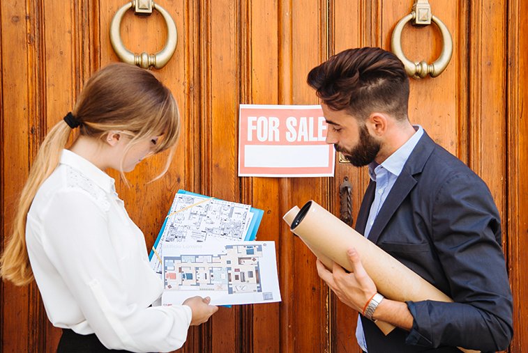 A couple in Ontario examines property listings outside a house with a 'For Sale' sign, indicating property search and offer support.