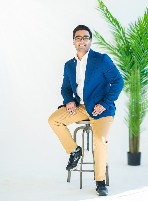 Confident professional man sitting on a stool in a bright room, representing private lending expert for second mortgages.