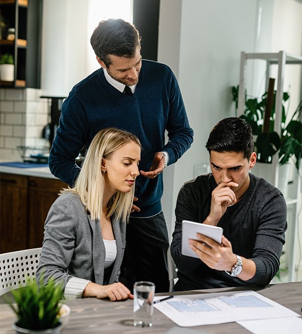 Couple consulting with mortgage advisor, reviewing documents and options for financing a vacation or second home.